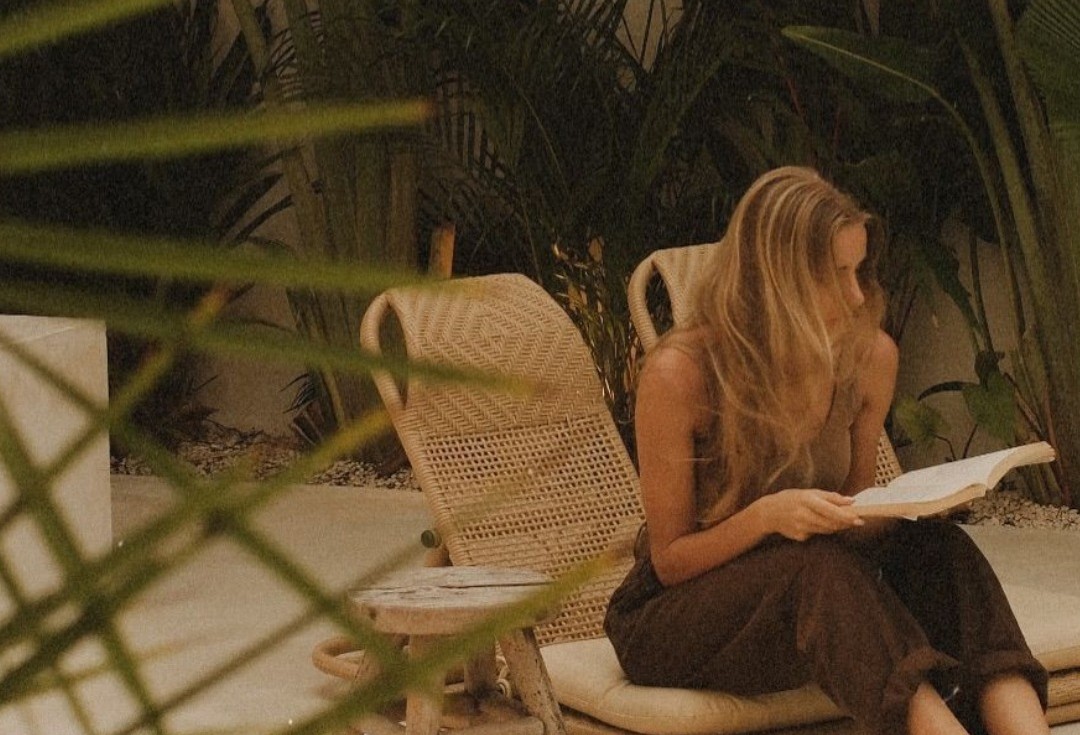 Mulher lendo em um jardim tranquilo, com luz natural